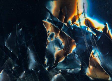 Foto de Scratched film texture. Crumpled noise. Distressed foil surface. Orange blue white color glow dust stains on dark black grunge abstract background. - Imagen libre de derechos
