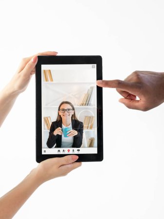 Téléchargez les photos : E-learning course. Video call. Digital education. Diverse students hands showing online lesson with cheerful female teacher on tablet screen isolated on white copy space. - en image libre de droit