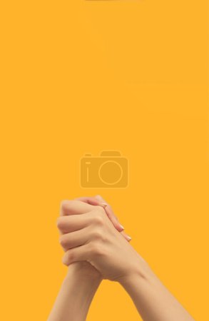 Téléchargez les photos : Support gesture. Victory congratulation. Solidarity unity. Female hands showing self-clasping handshake on orange copy space background. - en image libre de droit
