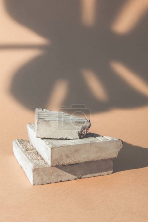 Foto de Rock platform. Product placement. Nature stage. Broken concrete stone brick stack stand palm leaf shadow on beige empty space promotional background. - Imagen libre de derechos