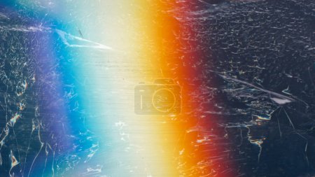 Photo for Old film noise. Rainbow light flare. Creased texture overlay. Orange blue white color glow dust scratches on dark rough black abstract background. - Royalty Free Image