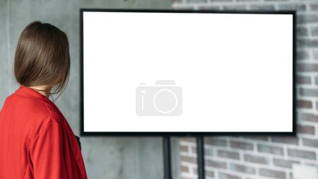 Photo for Office work. Digital mockup. Online presentation. Unrecognizable woman looking to projector blank screen staying light room interior. - Royalty Free Image