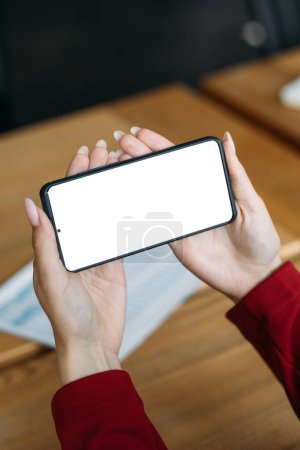 Photo for Mobile mockup. Virtual meeting. Digital technology. Female hands holding smartphone with blank screen sitting light room interior. - Royalty Free Image