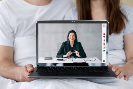 Photo for Video meeting. Couple counseling. Family psychotherapy. Cheerful female therapist working online on laptop screen with wife husband in bed. - Royalty Free Image