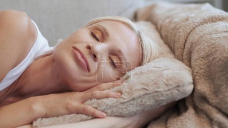 Photo for Home rest. Weekend relaxation. Lazy Sunday morning. Happy peaceful smiling senior woman with closed eyes enjoying napping on soft pillow on couch. - Royalty Free Image