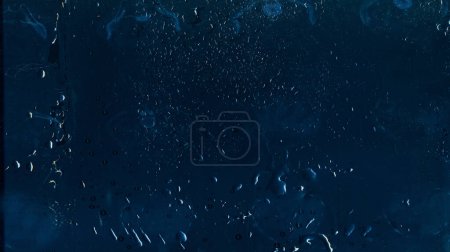 Foto de Vidrio mojado. Superposición angustiada. Ventana envejecida. Gotas de agua de lluvia polvo rasguños ruido en azul oscuro textura desgastada fondo ilustración abstracta. - Imagen libre de derechos