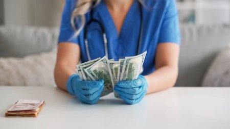 Photo for Medical profit. Expensive healthcare. Clinic budget. Unrecognizable female doctor in gloves counting money 100 bill American US dollar banknotes cash. - Royalty Free Image