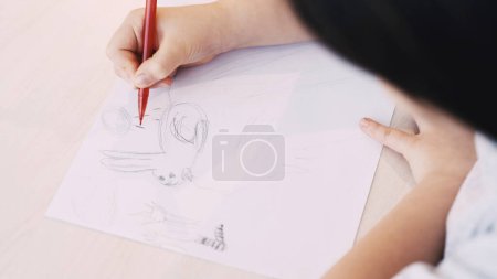 Photo for Cute picture. Kids painting. Art hobby. Unrecognizable child drawing rabbit on white paper with pencil sitting table. - Royalty Free Image