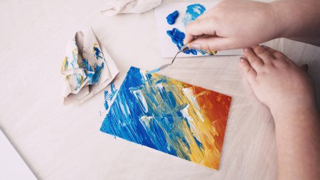 Photo for Art studio. Female artist. Creative process. Unrecognizable woman painting with spatula creating abstract picture on canvas. - Royalty Free Image