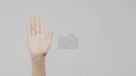 Téléchargez les photos : Bonjour geste. Panneau de bienvenue. Main féminine sur fond d'espace de copie lumière. - en image libre de droit