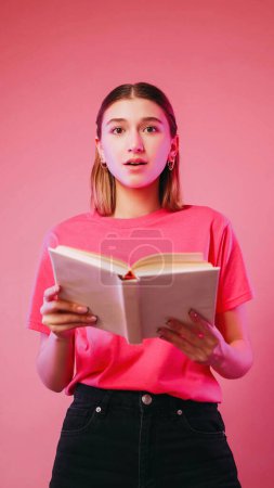 Photo for Surprised novel. Interesting reading. Astonished amazed girl holding book incredible plot text isolated on neon color pink background. - Royalty Free Image