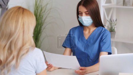 Photo for Medical consultation. Clinic appointment. Female doctor communicating with patient diagnosing studying medical history in hospital. - Royalty Free Image