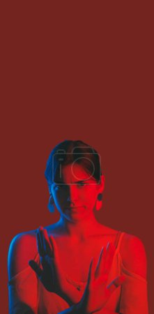 Photo for Forbidden girl. No way gesture. Strict serious neon light color woman crossing hands showing refusal sign isolated on dark red copy space background. - Royalty Free Image