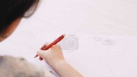 Photo for Creative picture. Kids painting. Art hobby. Unrecognizable child drawing on white paper with pencil sitting table blurred. - Royalty Free Image