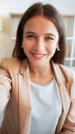 Photo for Happy selfie. Warm smile. Sincere emotions. Positive cheerful attractive beautiful young business woman taking photo in light interior. - Royalty Free Image
