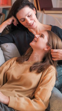 Photo for Parent relationship. Family communication. Happy woman stroking daughter hair warm talking at home leisure together sitting light interior. - Royalty Free Image