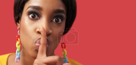 Photo for Secret hush. Keep quiet. Stop talking. Disturbed scared woman with colorful face makeup warning with shh finger gesture isolated on pink empty space background. - Royalty Free Image