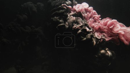 Foto de Pintura de agua. Nube de niebla. Salpicadura de fluido submarino. Flujo de humo de color negro rosa partículas de polvo de purpurina sobre fondo de arte abstracto oscuro. - Imagen libre de derechos