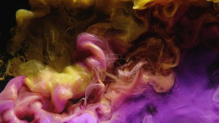 Photo for Ink water shot. Color smoke cloud. Fluid mix. Yellow pink purple glowing paint mix splash glitter dust particles on dark black abstract art background. - Royalty Free Image