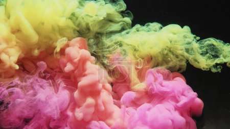 Foto de Una inyección de agua de tinta. Nube de humo. Explosión submarina. Pastel rosa amarillo tinte mezcla flujo de onda sobre fondo de arte abstracto negro. - Imagen libre de derechos
