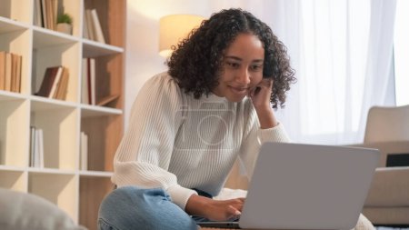 Photo for Internet connection. Remote work. Online communication. Joyful woman chatting laptop enjoying weekend indoors at home living room. - Royalty Free Image