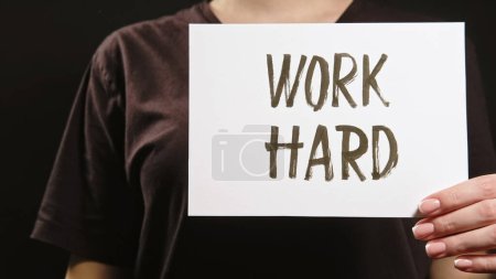 Photo for Work hard slogan. Growth motivation. Strength development. Unrecognizable woman supporting with encouragement advice sign on dark black free space. - Royalty Free Image