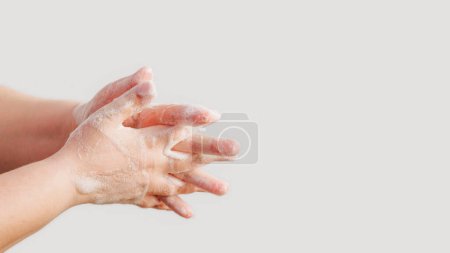 Photo for Hygiene habit. Microbe prevention. Woman washing hands with sanitizing soap foam protecting skin from bacteria isolated on white background empty space. - Royalty Free Image