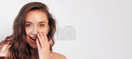Photo for Amazement gesture. Advertising surprise. Discount novelty. Shocked pretty woman with natural makeup perfect face skin hand to open mouth isolated on white empty space. - Royalty Free Image