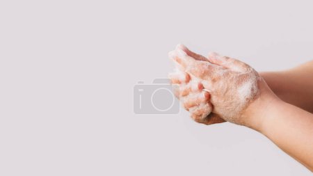 Photo for Hand hygiene. Infection prevention. Woman washing rubbing cleansing palms fingers skin with soap foam getting rid of bacteria isolated on white background empty space. - Royalty Free Image