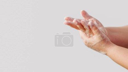 Photo for Hands washing. Personal hygiene. Woman disinfecting palm skin with antibacterial soap foam thoroughly isolated on white background empty space. - Royalty Free Image