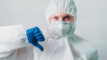 Photo for Ecology scientist. Infection epidemic. Dislike gesture. Lab specialist woman in ppe goggles mask glove thumb down hand sign contamination risk attitude isolated on grey background. - Royalty Free Image