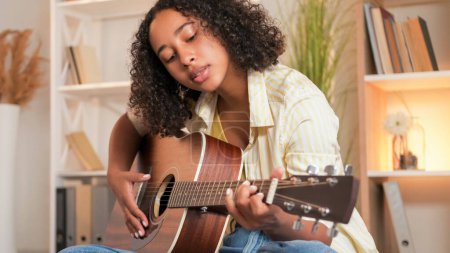 Photo for Guitar playing. Music lesson. Creative hobby. Talented woman singer performing acoustic string instrument melody at home. - Royalty Free Image