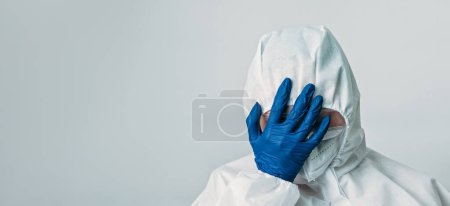 Photo for Medical fail. Frustrated scientist. Hospital stress. Doctor in white ppe coverall blue gloves with facepalm hand gesture isolated on grey background empty space. - Royalty Free Image