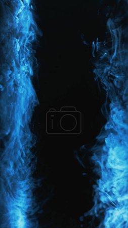 Téléchargez les photos : Cadre de brouillard. Fumée de fond. De la vapeur ésotérique. néon lumière bleu couleur froid gaz vapeur vague texture sur sombre noir abstrait copie espace. - en image libre de droit