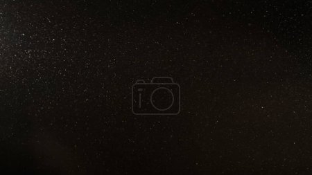 Photo for Dust particles. Grain texture overlay. Snow flakes. Defocused white powder flying floating on dark black abstract free space background. - Royalty Free Image