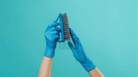 Photo for Household brush. Effective cleaning. Janitor touching professional hard high quality bristles washing tool with hands in protective gloves isolated on green background copy space. - Royalty Free Image