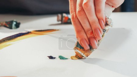 Photo for Drawing process. Artistic equipment. Unrecognizable woman painter hands squeezing paint out of tube creating picture in studio. - Royalty Free Image