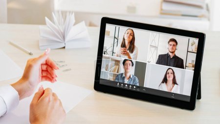 Photo for Video meeting. Business webcast. Diverse multiethnic men women team on tablet screen on corporate call with female CEO at home office workplace. - Royalty Free Image