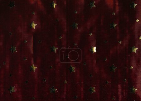 Photo for Fabric texture. Stars design. Abstract background. Brown red ribbed textile sample with defects glowing golden starlet pattern. - Royalty Free Image