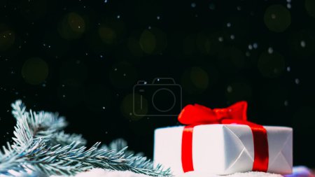Foto de Composición navideña. Decoración de regalo. Caja de regalo envuelto papel blanco con cinta roja en xmas rama de pino desenfoque brillo nieve bokeh luces espacio de copia de fondo. - Imagen libre de derechos