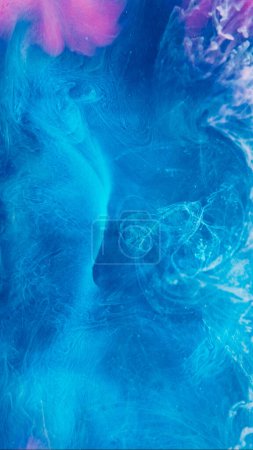 Foto de Fondo de humo misterioso. Un vapor mágico. Mezcla de pintura de agua rosa azul hipnótica etérea propagación en cautivante tinta líquida colorida arte creativo. - Imagen libre de derechos