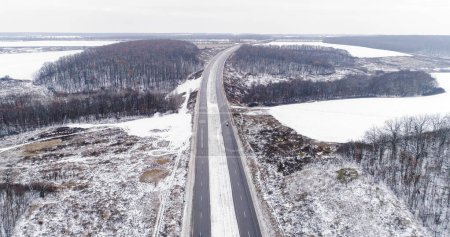 Photo for Aerial winter track. Snowy road. White frozen forest lakes cloudy day countryside asphalted driveway pavement cold season drone view. - Royalty Free Image