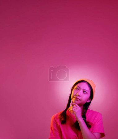 Ideenmoment. Brillant gedacht. Stirnrunzeln konzentrierte junge Frau konzentrierte sich auf knifflige Aufgabe Lösung isoliert auf rosa Scheinwerferhintergrund leeren Raum.