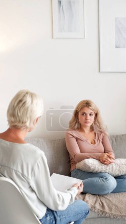 Photo for Psychologist consultation. Counseling support. Unhappy young woman and doctor conversation at psychotherapy appointment at clinic office copy space. - Royalty Free Image