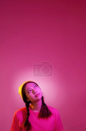 Inspirationsmoment. Idee eureka. Junge lässige smarte Frau Kopf mit brillanten Gedanken Licht isoliert auf rosa Hintergrund leeren Raum umgeben.
