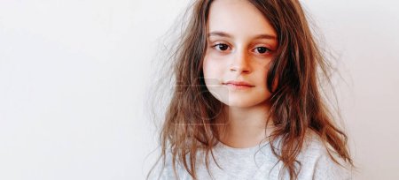 Photo for Child portrait. Kid face. Calm serious little girl with dry tousled tangled untidy messy hair isolated on white empty space background. - Royalty Free Image