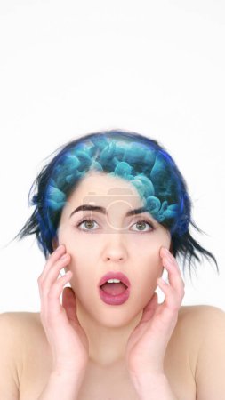 Brainwashing manipulation. Thought control. Shocked scared woman with blue smoke cloud hair effect isolated on white background empty space.