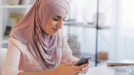 Photo for Mobile chatting. Digital communication. Smiling woman texting sms message on cell phone on internet social media app at home desktop copy space. - Royalty Free Image