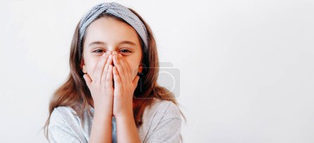 Photo for Amazed child. Kid surprise. Happy excited impressed little girl covering open mouth with hands showing wow reaction isolated on white empty space background. - Royalty Free Image