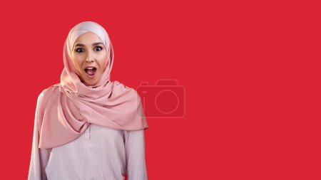 Téléchargez les photos : Wow surprise. Superbe visage. Réaction positive. Impressionné étonné excité femme heureuse dans hijab isolé sur fond d'espace vide rouge. - en image libre de droit